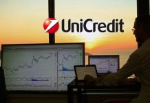 Azioni Unicredit: come reagiranno i prezzi alla trimestrale? chart di trading con sullo sfondo insegna di Unicredit