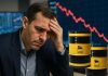 investitore preoccupato e barili di petrolio